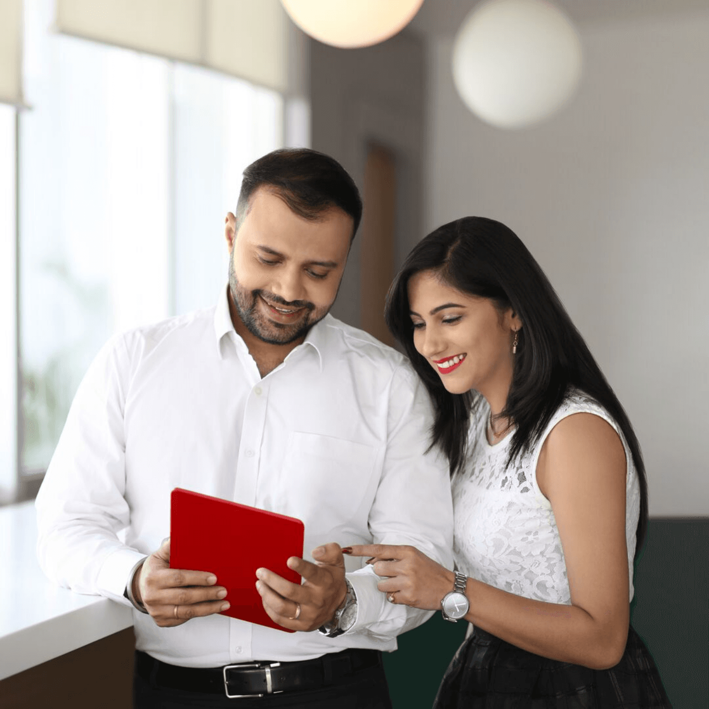 ratio-1-1-young-indian-couple-looking-at-a-tablet@3x