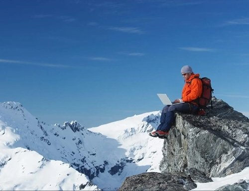 Man on mountain with laptop